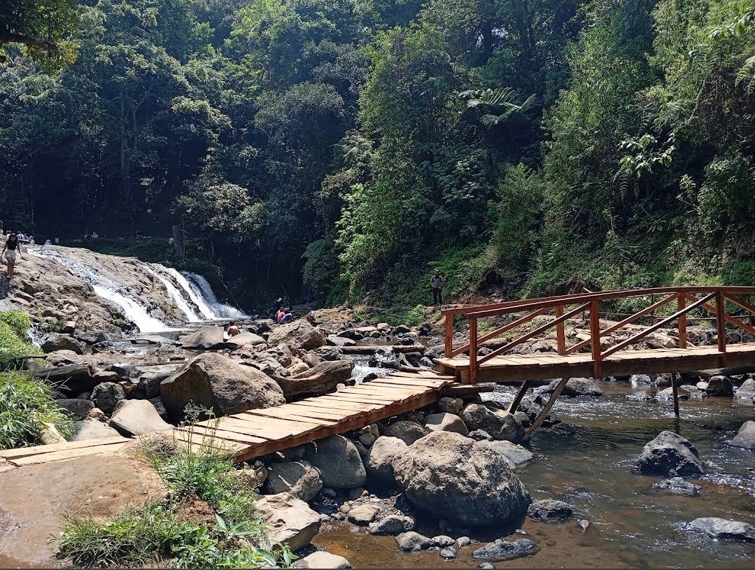 Jembatan kayu dan aliran air di kawasan Curug Layung